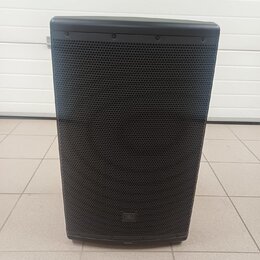 Černý reproduktor s kovovou mřížkou. V dolní části mřížky je umístěno logo JBL. Povrch vypadá čistě a bez viditelných poškození.