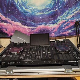 Černý DJ 컨트롤러 Denon DJ umístěný v hliníkovém transportním kufru. Na přístroji je vidět nápis DENON DJ a logo engine dj. Zařízení má dvě otáčivé jog-k…