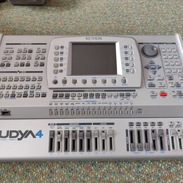 Stříbrný aranžér Ketron Audya 4 s nápisem „AUDYA 4 advanced music station“ v levém dolním rohu a logem „KETRON“ nahoře. Přístroj disponuje LCD disple…