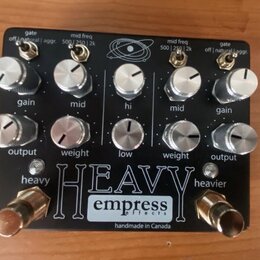 Černý kytarový efekt s nápisem HEAVY a logem empress effects. Na spodní straně je text handmade in Canada. Zařízení má deset stříbrných otočných knof…