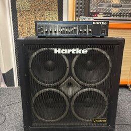 Černý basový reproduktor Hartke s čtyřmi membránami za kovovou mřížkou. V pravém dolním rohu je štítek s nápisem VX series ULTRA PACK a v horní části…
