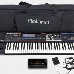 Černý syntetizátor s klaviaturou, na kterém je vpravo nápis Roland JUNO-60. Součástí sady je černý transportní vak s bílým logem Roland, napájecí ada…