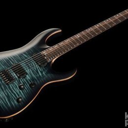 Elektrická kytara s tmavě modrým probarvovaným topem s viditelnou strukturou dřeva a černým hardwarem. Nástroj má dva humbuckery, dvě ovládací knoflí…