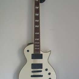 Bílá elektrická kytara s tvarem připomínajícím Les Paul a černým hmatníkem. Na hlavě je bílé logo Ltd. Nástroj má dva černý humbuckery, tři ovládací…
