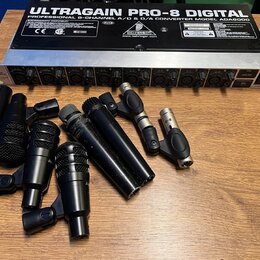 Na fotografii je rackové zařízení stříbrné barvy s nápisem ULTRAGAIN PRO-8 DIGITAL PROFESSIONAL 8-CHANNEL A/D & D/A CONVERTER MODEL ADAT8000 a logem…