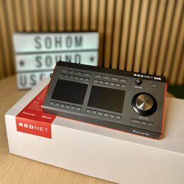 Šedý rackový audio rozhraní s nápisem REDNET R1 a logem Focusrite. Zařízení má dvě displejové obrazovky, řadu tlačítek a velký ovládací knoflík s náp…