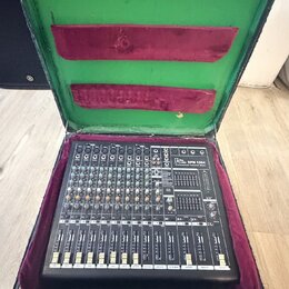 Černý mixážní pult v přepravním kufru s fialovou a zelenou výstelkou. Na přístroji je nápis "Behringer DFM 1094 Professional Powered Mixer". Jsou vid…
