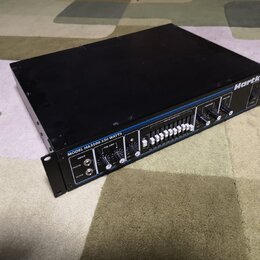 Černý rackový zesilovač s modrými detaily. Na předním panelu je nápis MODEL HA3500 350 WATTS a logo Hartke. Zařízení obsahuje několik regulačních kno…