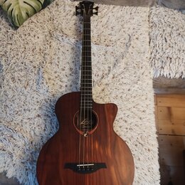 Akustická kytara s hnědým dřevěným povrchem a výřezem v těle. U otvoru je viditelné logo „Leko“ a pod ním nápis „Guitar“. Nástroj je v dobrém stavdu…