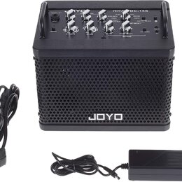 Černý kytarový kombo zesilovač s nápisem JOYO a označením modelu DC-15S. K zesilovači patří černý nožní spínáč s nápisy JOYO, DC-15S FOOTSWITCH, PRES…