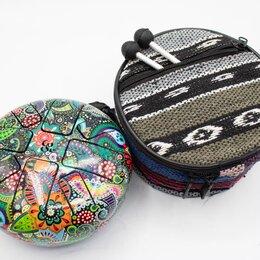 Kulatý perkusní nástroj s barevným, psychedelickým vzorem v různých odstínech červené, žluté, zelené a modré. Vedle něj je kulatý textilní pouzdro s…