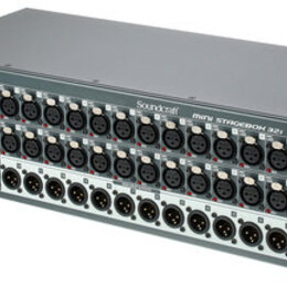 Šedý rackový přístroj s modrým bočním panelem. Na přední straně je nápis Soundcraft a MINI STAGEBOX 32I. Zařízení obsahuje několik řad konektorů XLR,…