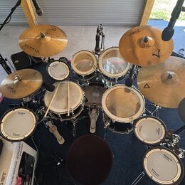 Sada bicích bubnů s několika cymbally a elektronickými pady. Na cymbalech je vidět nápis Istanbul, na bubnech značka Roland. Soubor obsahuje různé ve…