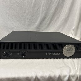 Černý rackový výkonový zesilovač s nápisem PV 900 a pod ním textem 500 WATT STEREO POWER AMPLIFIER. Na pravé straně je kulaté logo Peavey a nápis PV…