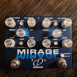 Modrý kytarový efekt s nápisem MIRAGE a logem crazy tube circuits. Zařízení má osm stříbrných otočných knoflíků s popisky swell, volume, voice, mix a…