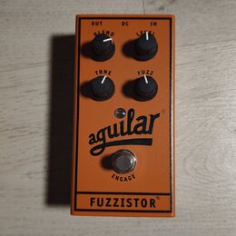 Oranžový kytarový efekt pedál s nápisy BLEND, LEVEL, TONE a FUZZ u ovládacích knoflíků. Uprostřed je černé logo aguilar a v dolní části nápis FUZZIST…