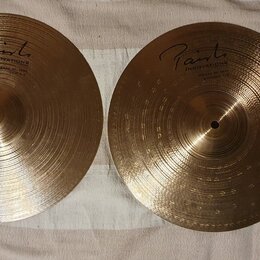 Dvě zlatavé kovové činely s koncentrickým rýhováním. Na obou je viditelné logo Paiste a nápis INNOVATION. Povrch je čistý bez viditelných poškzení.