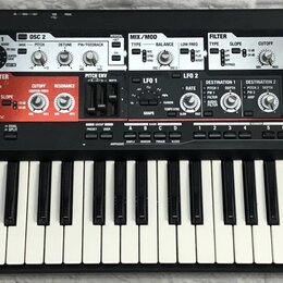 Černý syntetizátor s bílými a černými klávesami. Na levé straně je bílý nápis Roland SH-201 SYNTHESIZER. Horní panel obsahuje množství ovládacích prv…
