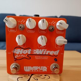 Oranžový kytarový efekt s bílými ovládacími knoflíky a dvěma stoupacími spínači. Na spodní části je bílý nápis Hot Wired, pod ním podpis B M Mason a…