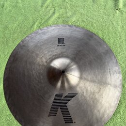 Kovový činel typu ride s matným, broušeným povrchem. Na povrchu jsou černé nápisy RIDE a 20"/51 cm oraz velké stylizované logo K. Činel vykazuje mírn…