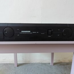 Černý rackový zesilovač s nápisem SAMSON STUDIO AMPLIFIER 85 WATT STEREO SERVO-170. Na předním panelu jsou dvě velké otočné potenciometry, vypínač PO…