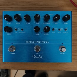 Modrý kytarový efekt s nápisem REFLECTING POOL a logem Fender. Zařízení má tři spínací tlačítka označená jako REVERB, TAP a DELAY. Na pravé straně se…