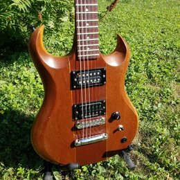 Elektrická kytara s hnědým dřevěným povrchem a dvěma humbuckery. Na spodním snímači je viditelný nápis "Seymour Duncan". Kytara má jeden ovládací kno…