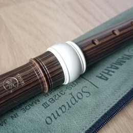 Hnědá sopránová bloková flétna s imitací dřevěného povrchu a bílým plastovým spojem. Na nástroji je vyryto logo Yamaha a nápis MADE IN JAPAN. Flétna…