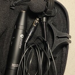 V černém zipovém pouzdře se nachází mikrofon s čelníkem, kabel a plastový držák. Na černém těle mikrofonu je bílý nápis "prodipe" s logem a text "Mad…