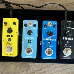 Sada efektů pro kytaru na černém pedalboardu. Zleva jsou vidět černé pedál s nápisem VOLWAH a šest barevných pedálů značky Rowin: žlutý DELAY, světle…