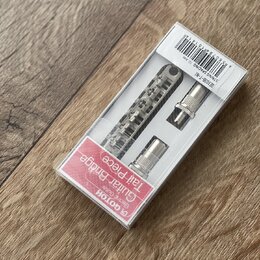 V průhledném plastovém obalu jsou umístěny kovové části mostu a strunovníku pro elektrickou kytaru v chromovaném provedení. Na červeném štítku je náp…
