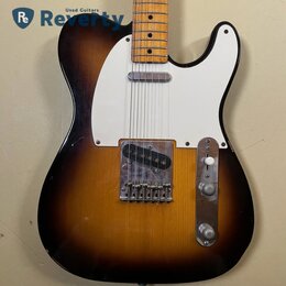Elektrická kytara s tělem v provedení sunburst a bílým pickguardem. Na kovovém krytu snímače je čitelně napsáno "TOWSON". Nástroj vykazuje známky opo…