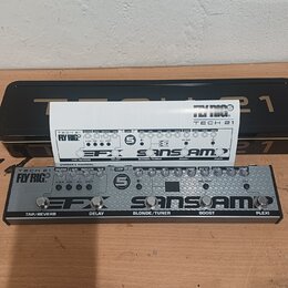 Kytarový efekt pedál stříbrné barvy s nápisy TECH 21 Fly RIG, EFX a SANSAMP. Na spodní straně jsou označení TAP/REVERB, DELAY, BLONDE/TUNER, BOOST a…