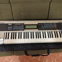 Stříbrný digitální klavír s nápisy Roland a PRELUDE. Nástroj má standardní klávesnici, LCD displej uprostřed a několik ovládacích tlačítek v sekcích…