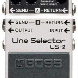 Kytarový pedál značky BOSS, model Line Selector LS-2. Zařízení má stříbrné kovové šasi s černým vypínacím pedálem, na kterém je vyražené logo BOSS. N…