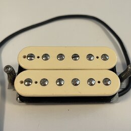 Kytarový humbucker s krémovými plastovými kryty. Snímač má dvě řady šesti poladitelných šroubů. Na povrchu nejsou viditelné žádné značky ani nápisy.…