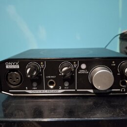 Černý zvukový interface s nápisy ONYX a Artist 1-2. Na přední straně jsou dva knofíky GAIN, jeden velký knofík MONITOR a přepínače +48V, LINE/INST a…