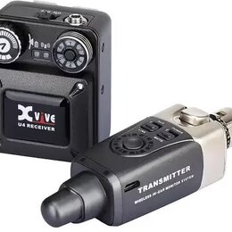 Sada bezdrátového systému pro in-ear monitoring v černé barvě. Na levém zařízení je nápis Xvive U4 RECEIVER a dvě otočné kontrolní kolečka. Pravé zař…