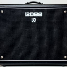 Černý kytarový kombo zesilovač s černou texturovanou síťovkou. Uprostřed je bílý nápis BOSS a pod ním symbol katany. V rozích jsou viditelné stříbrné…