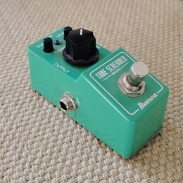 Zelený kytarový efekt pedál značky Ibanez s nápisem TUBE SCREAMER MINI. Na horní straně jsou tři černé ovládací knoflíky s popisky TON, OVERDRIVE a L…