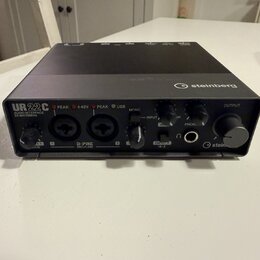 Černý audio rozhraní s nápisem UR22C AUDIO INTERFACE 32-bit/192Hz a logem steinberg. Na přední straně jsou dva kombinované vstupy D-PRE MIC/LINE, ovl…