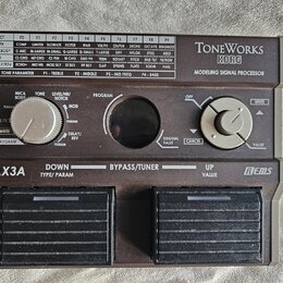 Hnědý efektový procesor s nápisy ToneWorks KORG a MODELING SIGNAL PROCESSOR. Zařízení má dvě šlapadla, dva otočné ovladače a tabulku efektů v horní č…
