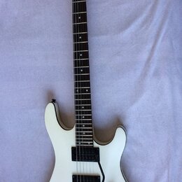 Bílá elektrická kytara s tmavým hmatníkem a dvěma humbuckery. Na hlavě je viditelné logo Cort. Nástroj vykazuje známky používání v podobě drobných šk…