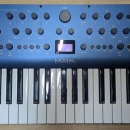 Modré synthesizátory s klaviaturaí. Na horním panelu je vlevo nápis COBALT 8 a uprostřed pod displejem značka MODAL ELECTRONICS, vpravo je logo M. Př…