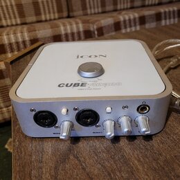 Bílá USB zvuková karta s kovovým stříbrným rámem. Na horní straně je nápis iCON, označení modelu CUBE 4mano a text USB2.0 High-Speed spolu s ovladače…