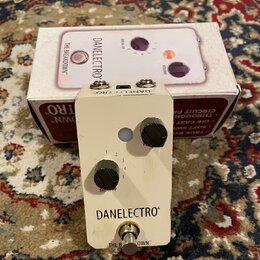 Bílý kytarový efekt pedál značky DANELECTRO s nápisem THE BREAKDOWN™. Na horní straně jsou dva černé otočné knoflíky s popisky VOLUME a BREAKUP (ozna…