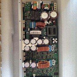 Fotografie zobrazuje elektronickou základní desku s komponenty, která je umístěna v ochranném polystyrenovém obalu. Na desce jsou vidět kondenzátory,…