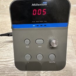 Šedý elektronický modul s černým displejem, na kterém svítí červená čísla 005. V horní části je bílý nápis Millenium a nad ním modrý štítek s nápisem…