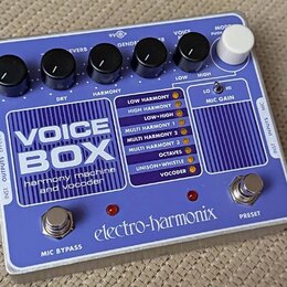 Modrý efektový pedál s bílým nápisem VOICE BOX a podtitulem harmony machine and Vocoder. Na spodní straně je logo electro-harmonix a dvě stříbrná tla…