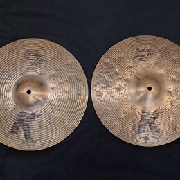 Dvě mosazné činely s výrazným kladivováním a černým logem K ve spodní části. Levý činele má nápisy Custom Special Dry a HIHAT BOTTOM 14" 70 cm. Pravý…